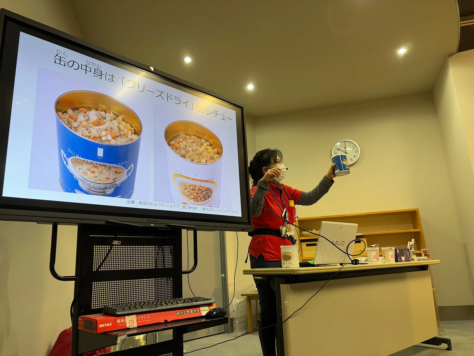 スタッフがサバイバルフーズを手に持って説明している様子2