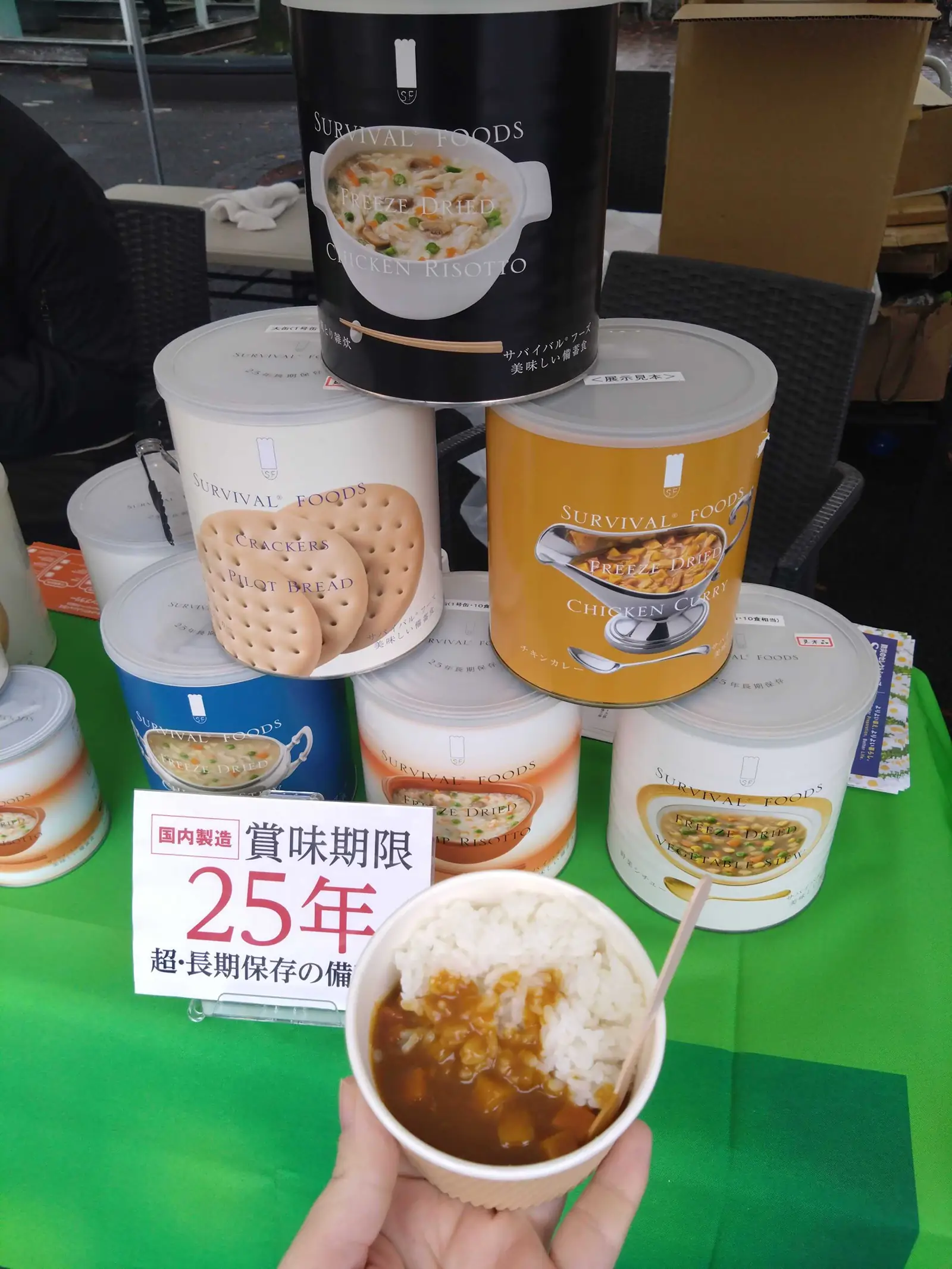 2025新宿防災チャレンジパークでのサバイバルフーズ製品缶とキッチンカーで提供されたチキンカレー